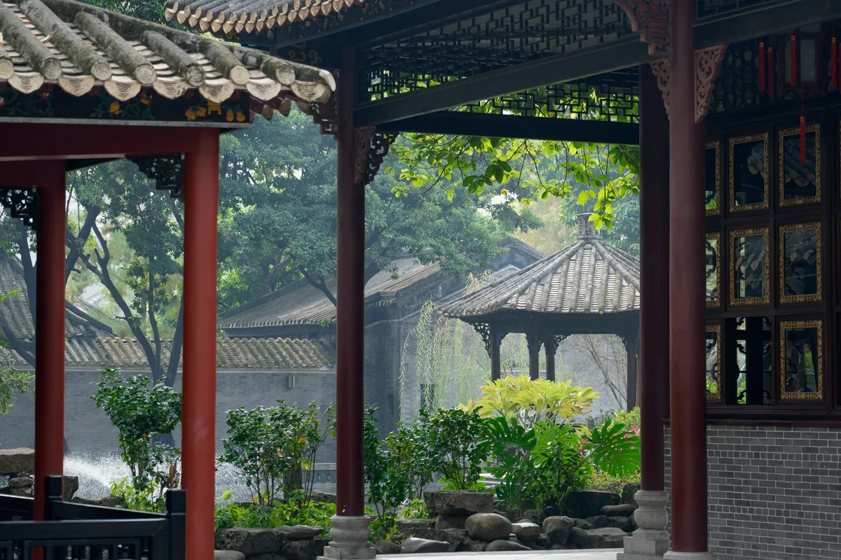 Pavillon à toit courbe et colonnes rouges, dans un jardin chinois